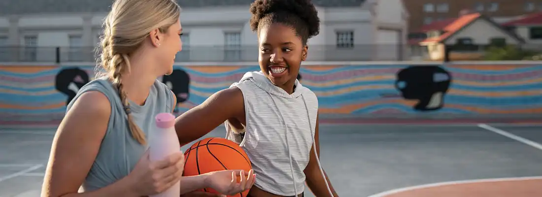 Two athletic women smiling, representing health, wellness, and digestive health.