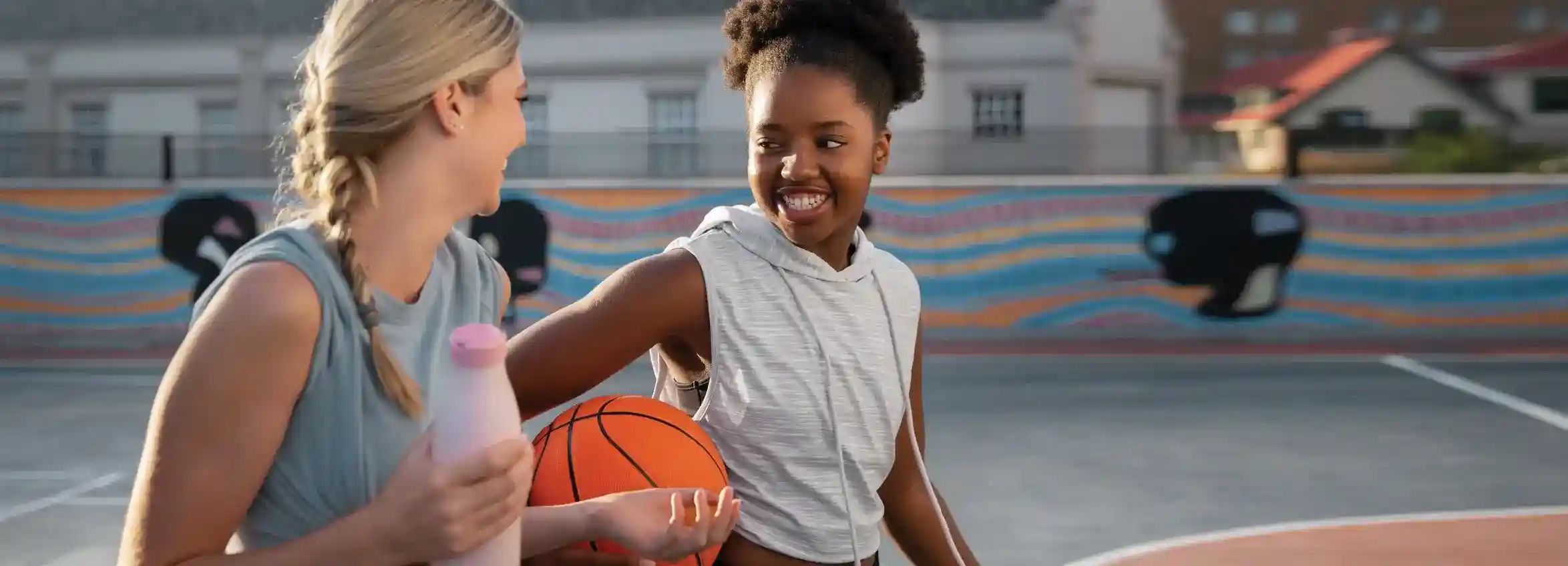 Two athletic women smiling, representing health, wellness, and digestive health.